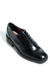 Fashionable female black leather shoes with silver details isolated on a white background.