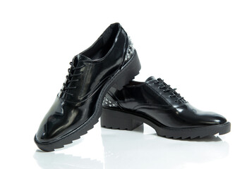 Fashionable female black leather shoes with silver details isolated on a white background.