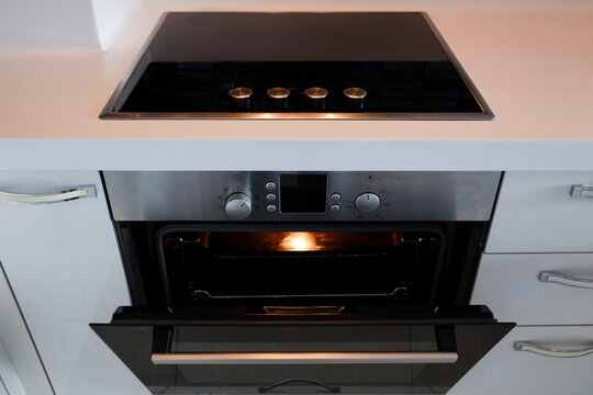 Modern black induction stove. Energy efficient electric hob with built-in oven at home kitchen . Close up, copy space, background, top view.