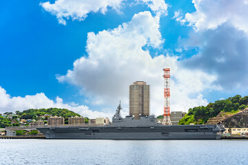 Obraz premium yokosuka, japan - july 19 2020: Wide angle view of the Japanese Destroyer JS Izumo DDH-183, an helicopter and aircraft carrier of Japan Maritime Self-Defense Forces berthed in the Yokosuka naval port.
