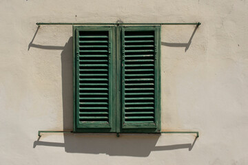 Italian Window with Wooden Shutters in a brick wall