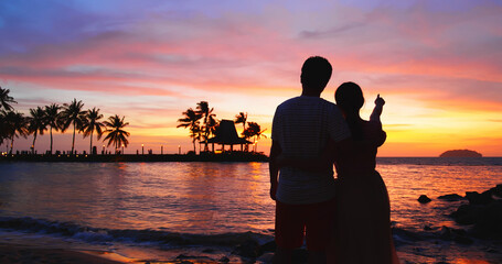 couple stand on sunset beach