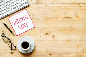 Wrong way icon on office desk - wooden, top view copy space