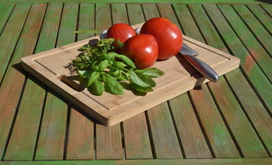 fresh tomatoes and herbs on a wooden table