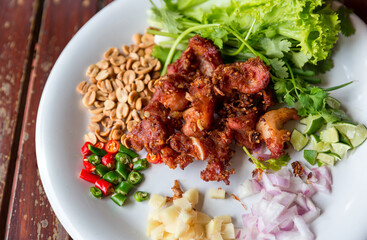 Fried pork rib served with side dish of Garlic, Chilli and Nut on plate. Favorite preservation food. Fried sour pork. Fried fermented pork ribs tasty