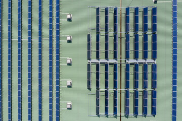 Solar panels and hot water heaters intalled on the building roof, aerial drone top down view