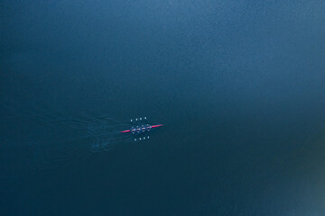 Boat coxed four rowers rowing on the blue river aerial drone top view - obrazy, fototapety, plakaty