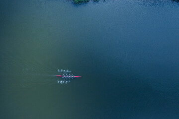 Boat coxed four rowers rowing on the river aerial drone top view