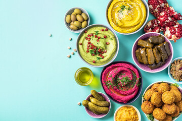 Arabic traditional cuisine. Middle Eastern meze with pita, olives, colorful hummus, falafel,...