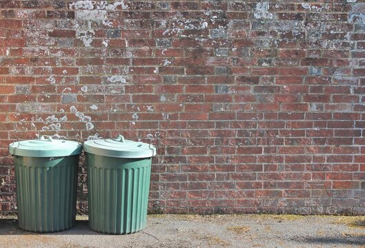 Trash Can Dustbins Trashcan Rubbish Bins Outside Against Brick Wall Background With Copy Space 