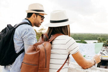 Happy tourist couple using the map. Travel and love concept in Latin America