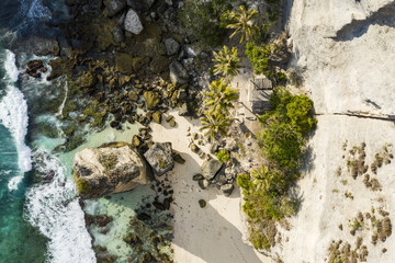 View from above, stunning aerial view of a green limestone cliff bathed by a turquoise sea during sunset. Nusa Penida, Indonesia. Nusa Penida is an island southeast of Bali, Indonesia.