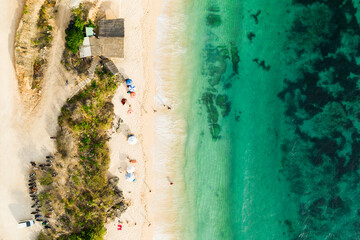 View from above, stunning aerial view of a beautiful beach bathed by a turquoise sea during sunset, Melasti Beach, South Bali, Indonesia.