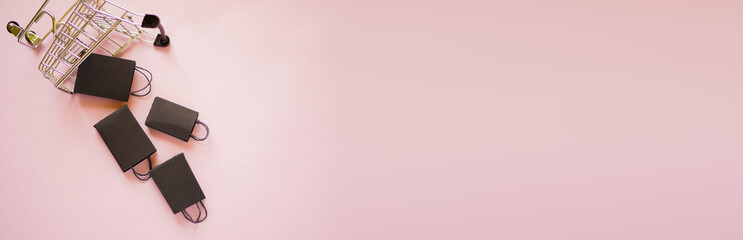 Flat lay shopping cart with paper bags. Black friday banner. Copy space. Pink color. Fast delivery....