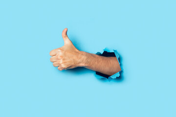 Male hand makes a hand up gesture on a blue background. Banner. Gesture all ok, like