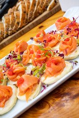 Salmon on little crepes with micro herbs surrounding them.