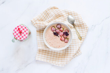 Strawberry yogurt and ripe strawberry on a white table
