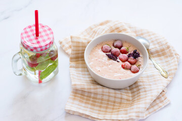 Strawberry yogurt and ripe strawberry on a white table