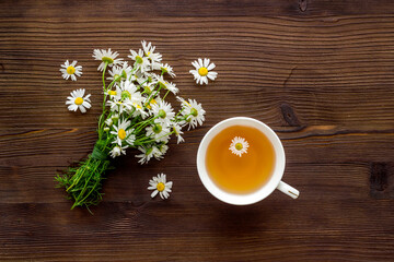 Herbal tea with chamomile flowers, top view copy space