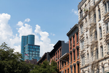 Obraz premium Row of Colorful Old Residential Buildings in the East Village of New York City with a Modern Glass Skyscraper