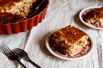 Apple and Cheese Cobbler Crisp. Cobbler or Crumble dessert with apples in ceramic baking form on beige linen table. Selective focus