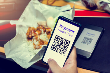 Selective focus to QR code tag on smartphone with blurry Chinese street food to accepted generate digital pay without money. Qr code payment concept.