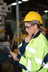 Portrait of Technician woman worker with hardhat working in industrial factory using laptop for checking  management information systems of manufacture © Somchai