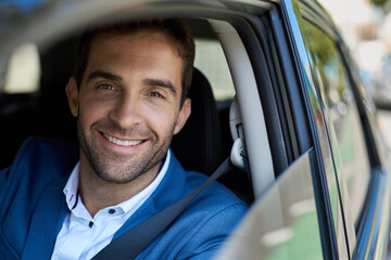 Smiling man sitting in his car during his morning commute