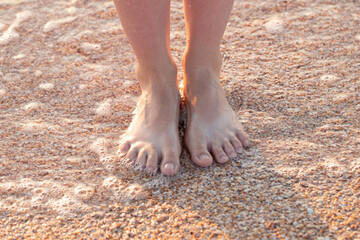 girl barefoot on the beach in summer. Feet in the water