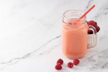 Berry smoothie in a glass jar on the breakfast with raspberries. Copy space