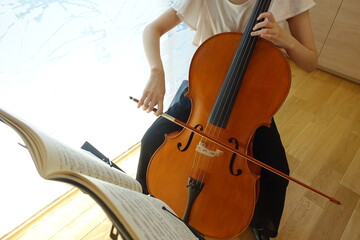 チェロを弾く女性　穏やかな光が射す部屋で　young woman playing the cello