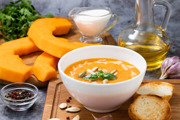Pumpkin cream soup with seeds on a stone background, with copy space