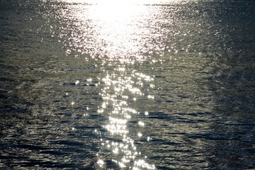 Shimmering sunlight reflections on the surface of the sea by sunset.