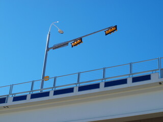 Naklejka premium Traffic signals from down below look like they do not go anywhere. Directly across is a long sloping exit that is an entrance to the Skyline Trail and a city park were birdwatchers see wild waterfowl.