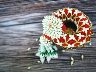 Thai traditional craft flower garland on wood background.