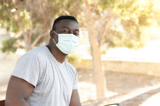 Black Man Wearing A Protective Facemask And Sitting On The Bench