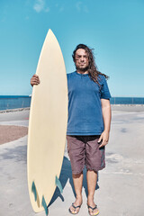 Fototapeta na wymiar Surfer Holds His Surfboard
