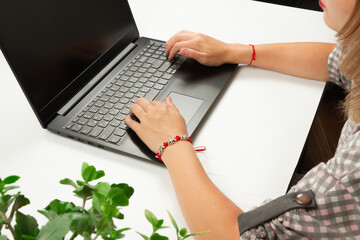 girl typing text on laptop keyboard on white wooden table background