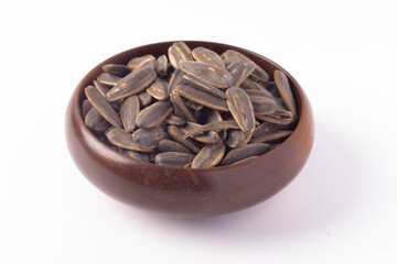 Dry sunflower seeds in a wooden cup on a white background