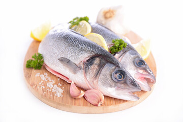 raw fish with salt and lemon on board isolated on white background