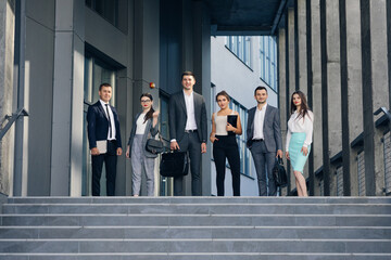 Happy proud professional diverse business people group look at camera. Corporate team portrait. Smiling team of diverse different generations business people looking at camera
