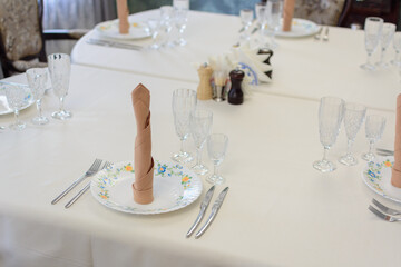 Beautiful table setting with white tablecloth and plates.