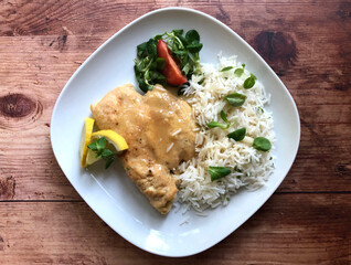 Chicken cutlet with sauce and rice. Delicious Austrian Naturschnitzel.