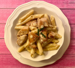 Creamy penne pasta with fry chicken strips.