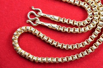 Golden necklace placed on the red velvet floor