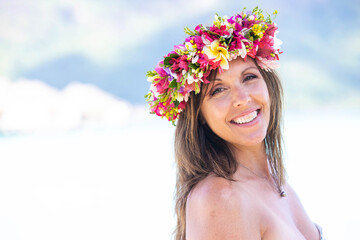 Beautiful woman wearing colorful flower crown while on a tropical island vacation in Bora Bora near...
