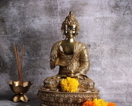 Brass sculpture of Gautam Buddha. Over grey background