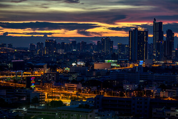 The high angle background of the city view with the secret light of the evening, blurring of night lights, showing the distribution of condominiums, dense homes in the capital community