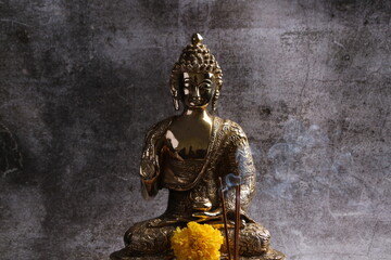 Brass sculpture of Gautam Buddha. Over grey background