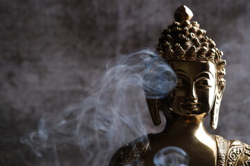 Brass sculpture of Gautam Buddha. Over grey background